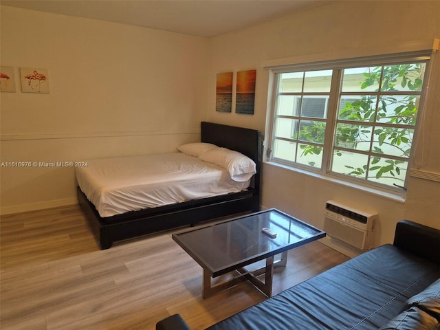 bedroom featuring a wall mounted AC and hardwood / wood-style floors