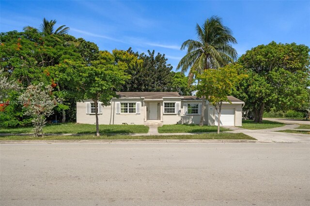 ranch-style home with a front yard and a garage