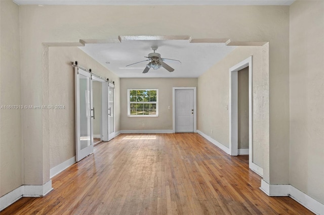 1400 SW 62nd Ave, West Miami, FL 33144 - empty room featuring a barn door, ceiling fan, and wood finished floors