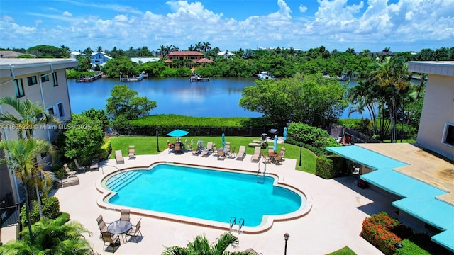 view of pool with a lawn, a water view, and a patio