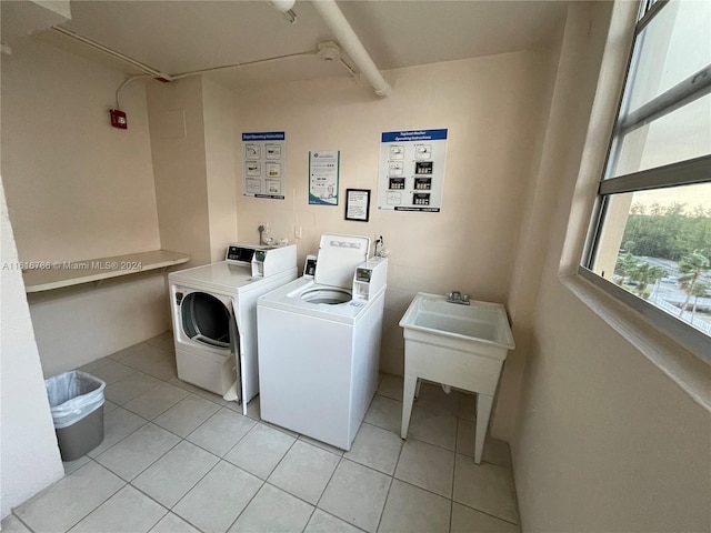 washroom featuring light tile patterned floors, sink, and washer and dryer