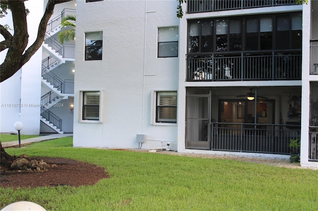 rear view of property with a balcony and a lawn