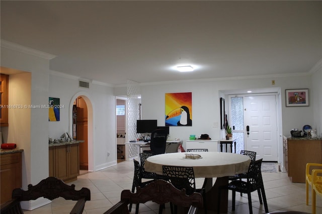 tiled dining room featuring crown molding