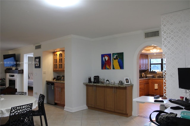 interior space featuring light tile patterned flooring, tasteful backsplash, dishwasher, stone counters, and ornamental molding