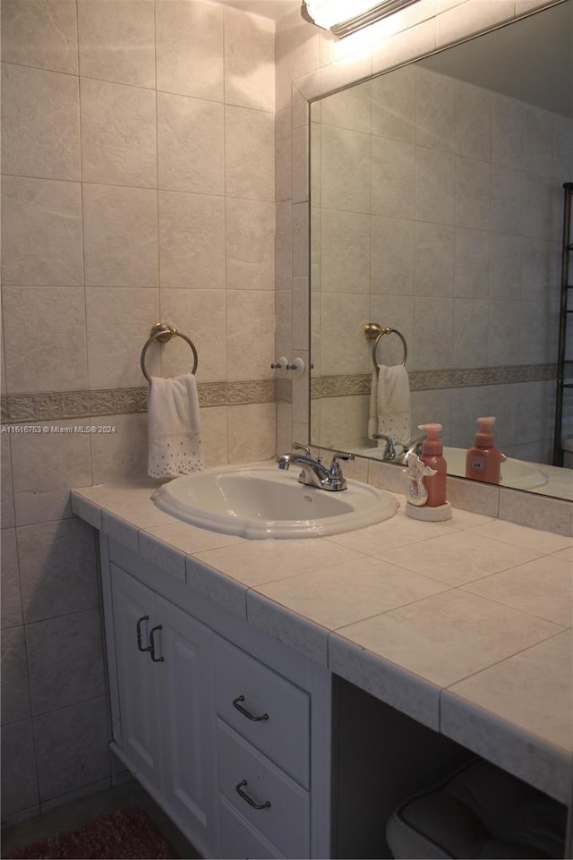 bathroom featuring vanity and tile walls