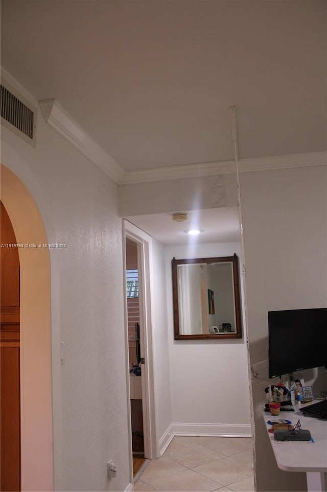 hallway featuring ornamental molding and light tile patterned flooring