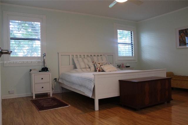 bedroom with dark hardwood / wood-style flooring, ceiling fan, and crown molding