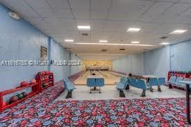 recreation room with carpet flooring and a drop ceiling