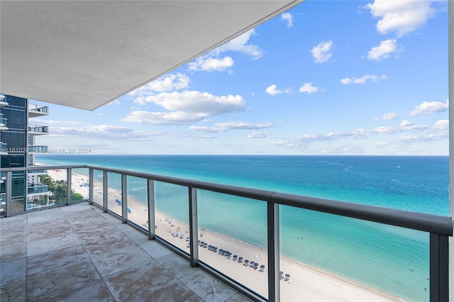 balcony featuring a beach view and a water view