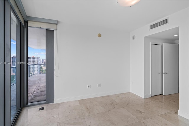 spare room with light tile patterned flooring and expansive windows