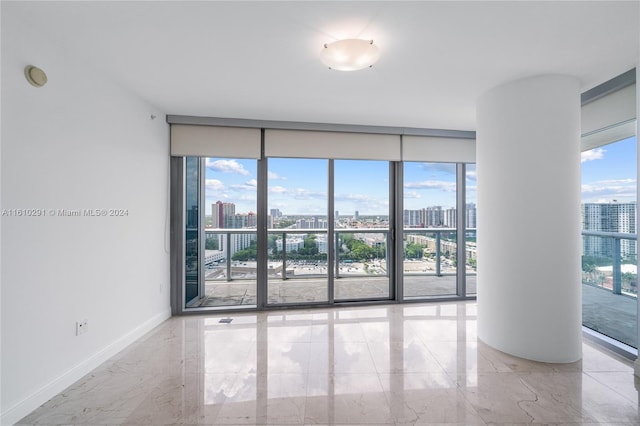 tiled empty room featuring expansive windows