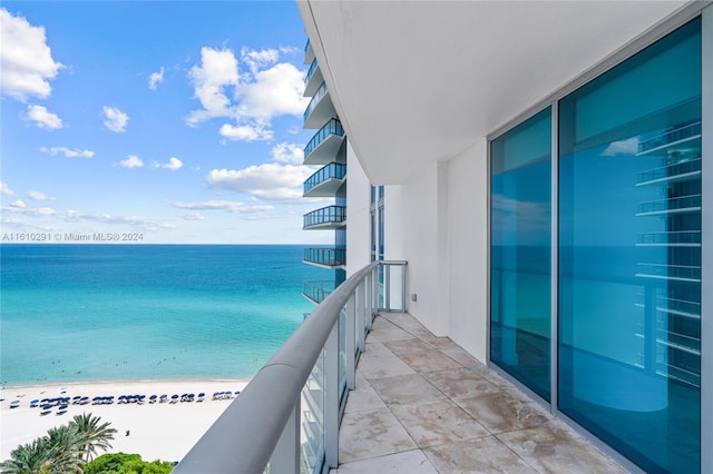 balcony featuring a water view and a view of the beach