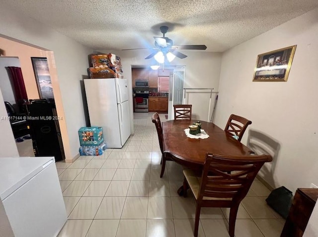 dining space with light tile patterned flooring, ceiling fan, and a textured ceiling