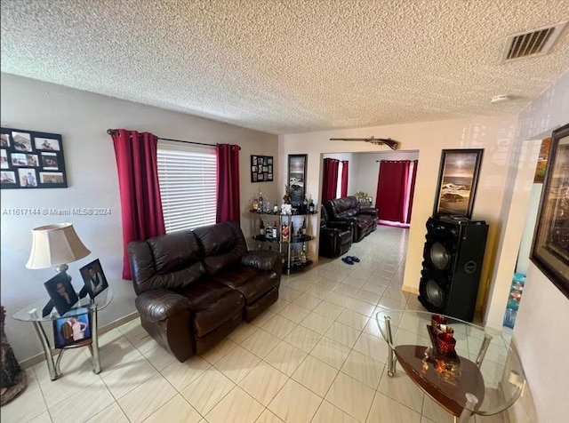 living room with a textured ceiling and light tile patterned floors