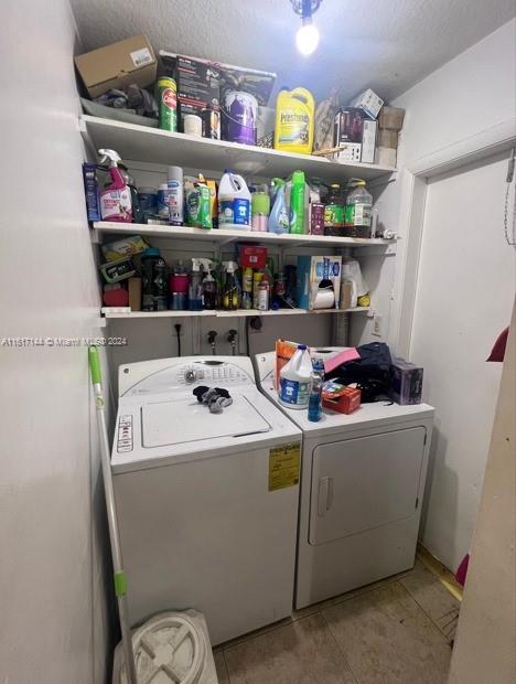 laundry area with light tile patterned flooring and washer and dryer