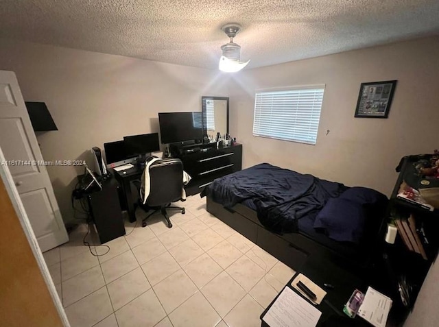 bedroom with light tile patterned flooring and a textured ceiling