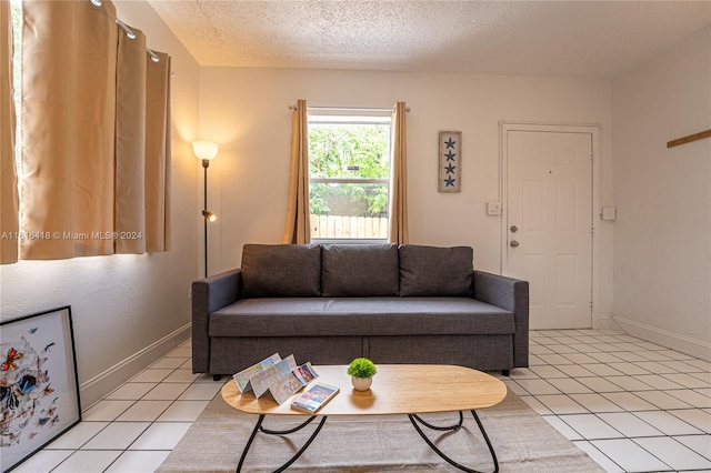 tiled living room featuring a textured ceiling