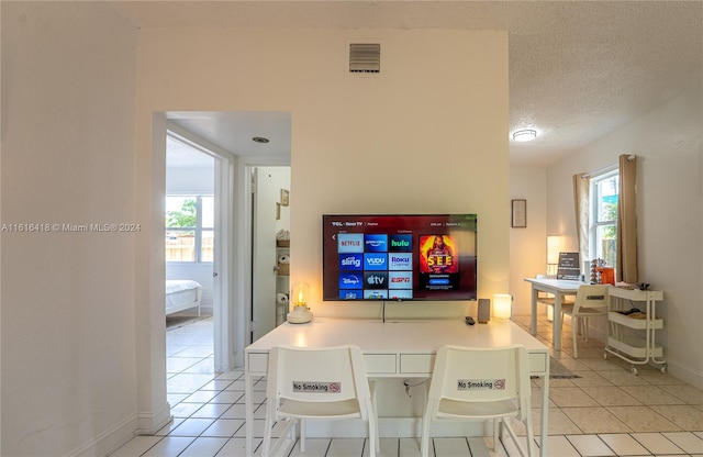 dining space with light tile patterned floors and a textured ceiling