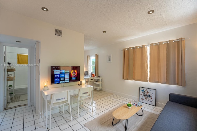 living room featuring a textured ceiling and light tile patterned floors