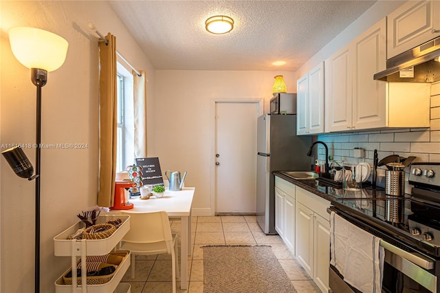 kitchen featuring white cabinetry, backsplash, stainless steel electric range, and light tile patterned floors