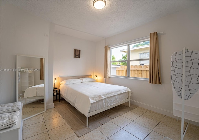 bedroom featuring light tile patterned floors and a textured ceiling