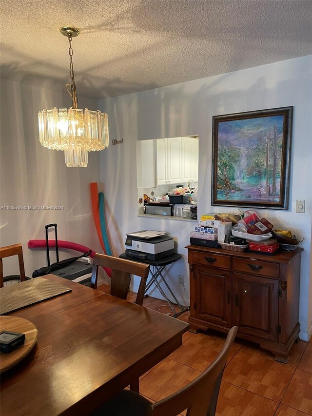 dining space featuring a notable chandelier and a textured ceiling