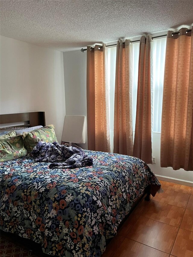 bedroom featuring multiple windows and a textured ceiling