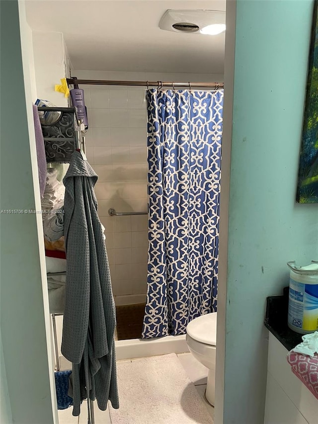 bathroom with a shower with curtain and toilet