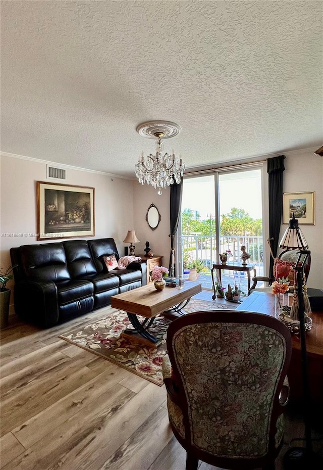 living room with ornamental molding, a chandelier, a textured ceiling, and hardwood / wood-style flooring