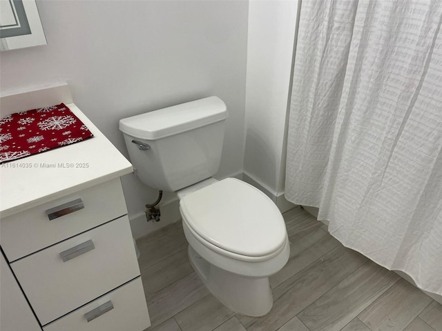 bathroom featuring vanity, hardwood / wood-style floors, and toilet