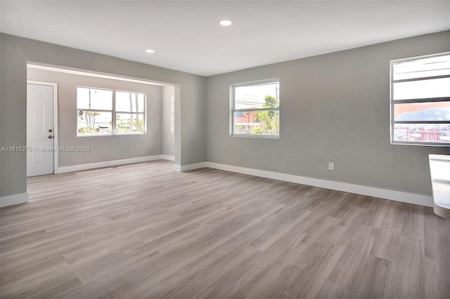 spare room with a wealth of natural light and light hardwood / wood-style flooring