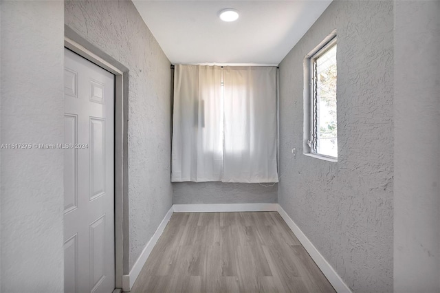 hallway with light hardwood / wood-style floors