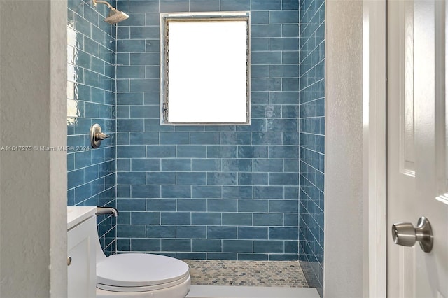 bathroom featuring vanity, toilet, and tiled shower