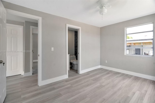 unfurnished bedroom featuring ensuite bathroom, ceiling fan, and light hardwood / wood-style floors