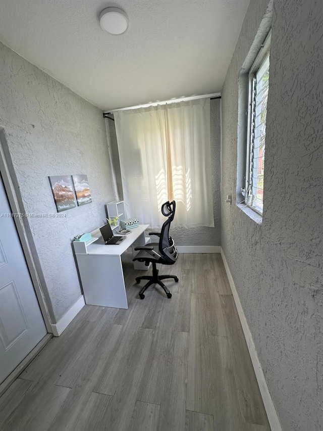 office space featuring a textured ceiling and light wood-type flooring