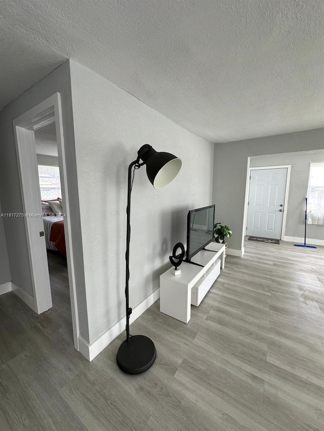 interior space with a textured ceiling and light hardwood / wood-style flooring