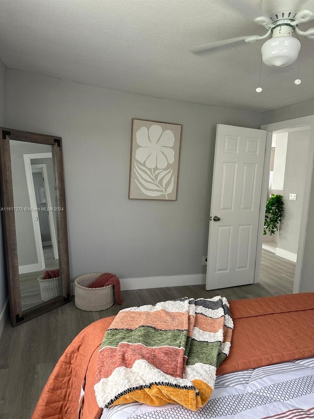 bedroom featuring ceiling fan, dark hardwood / wood-style floors, and a textured ceiling