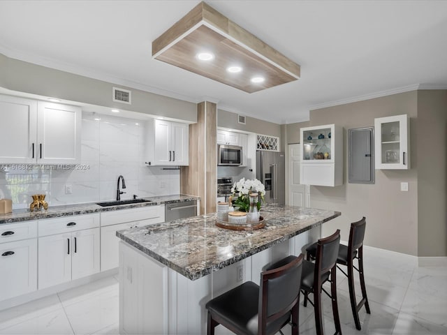 kitchen featuring white cabinets, a center island, stainless steel appliances, and sink