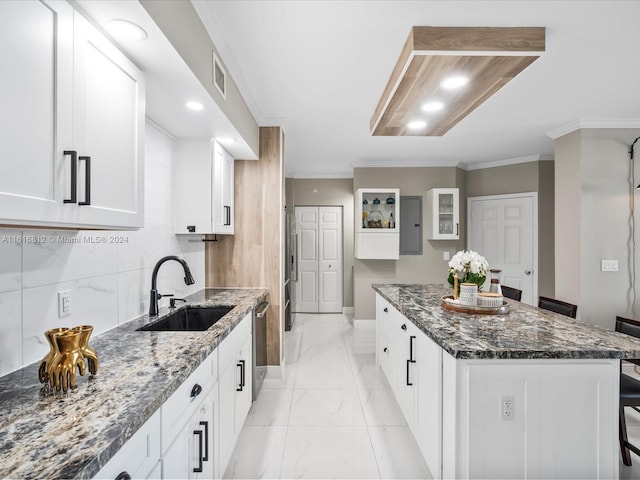 kitchen with a center island, a breakfast bar, sink, and white cabinets