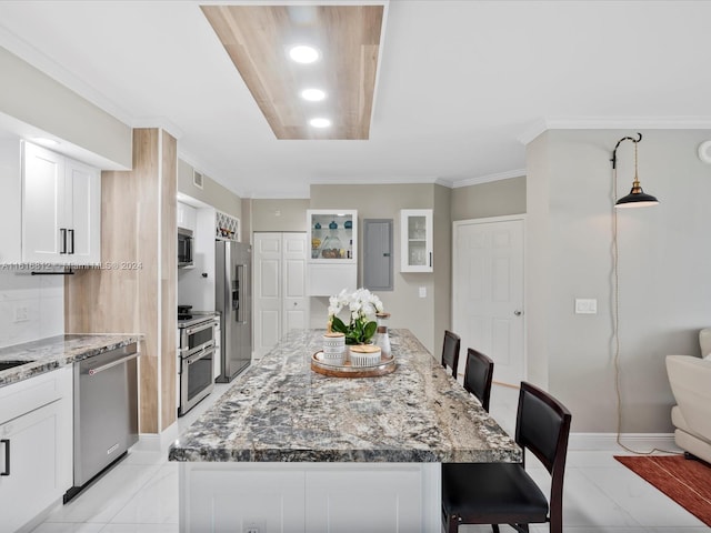 kitchen with a center island, a breakfast bar, white cabinets, and stainless steel appliances