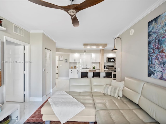 tiled living room featuring sink and ornamental molding