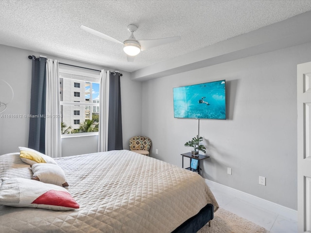 bedroom with ceiling fan and a textured ceiling