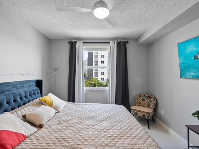 bedroom with ceiling fan and a textured ceiling