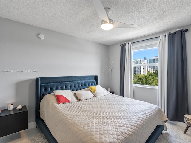 bedroom with ceiling fan and a textured ceiling