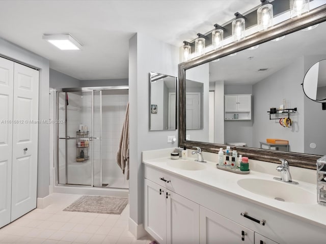 bathroom featuring tile patterned floors, vanity, an enclosed shower, and toilet