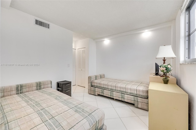 bedroom featuring light tile patterned floors and a closet