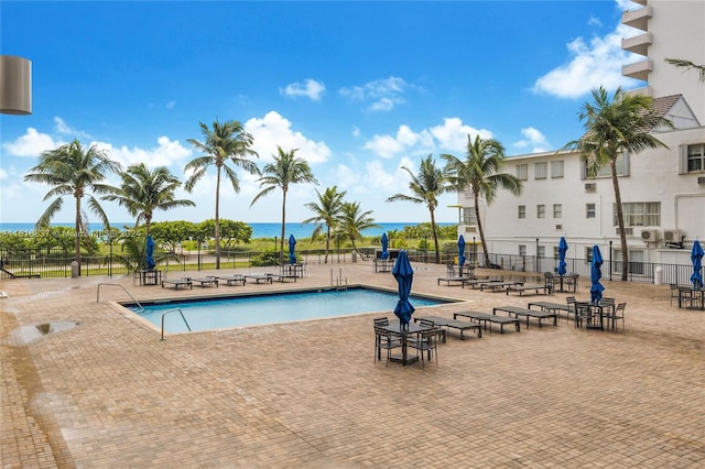 view of swimming pool with a water view and a patio