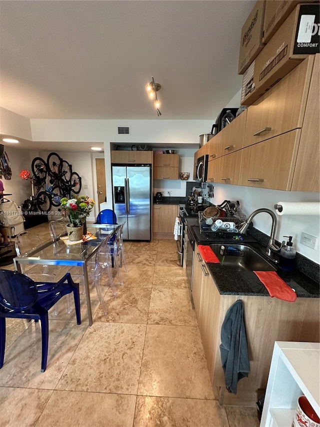 kitchen featuring appliances with stainless steel finishes, track lighting, sink, light tile patterned floors, and light brown cabinetry