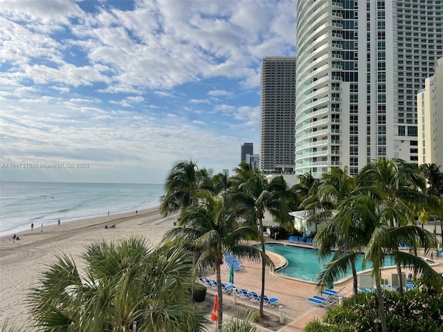 community pool with a water view and a beach view