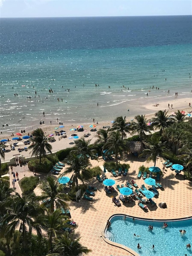 birds eye view of property with a water view and a beach view